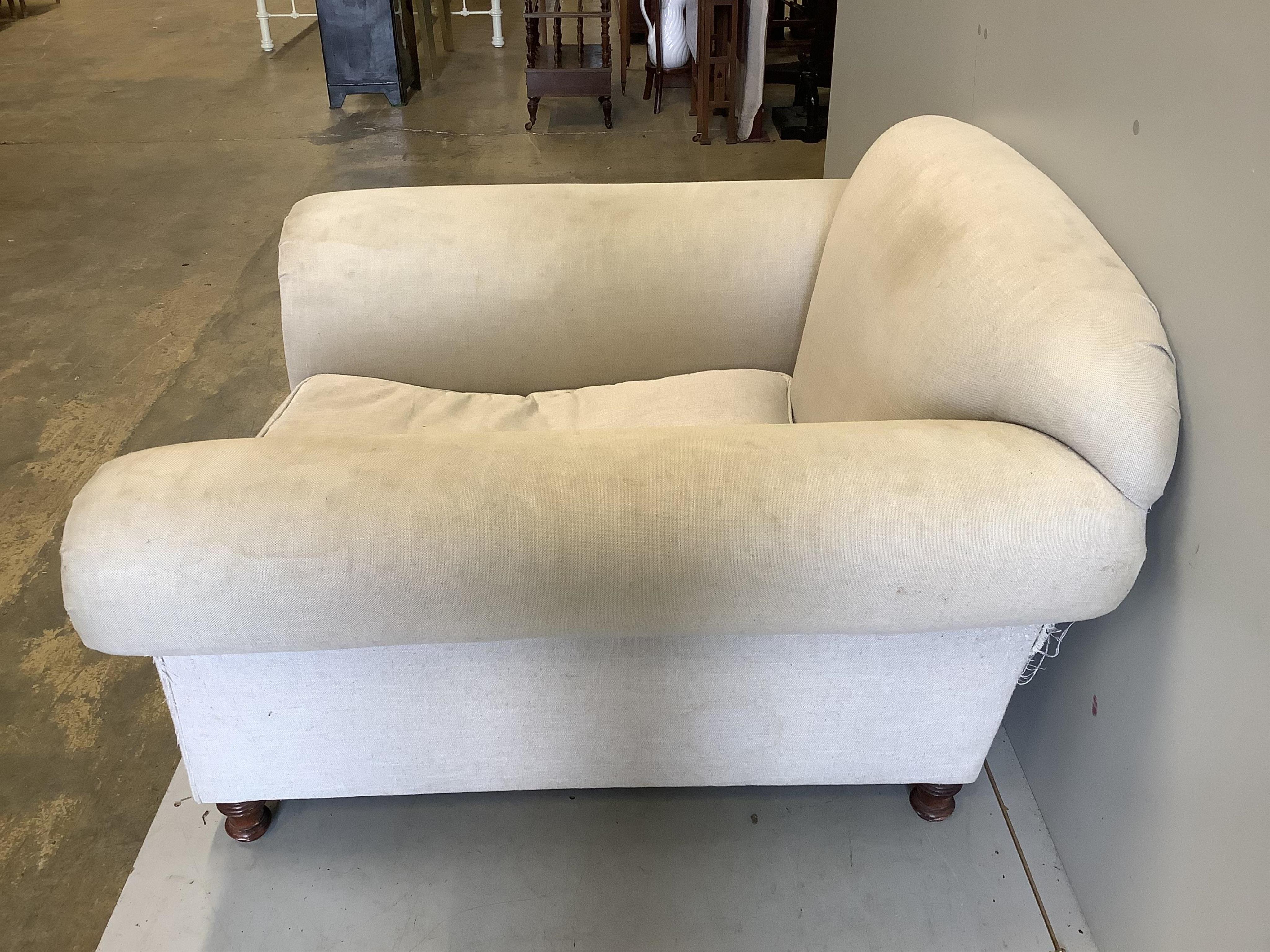 A Howard style upholstered armchair, width 115cm, depth 110cm, height 78cm. Condition - fair, upholstery scratched and requires cleaning